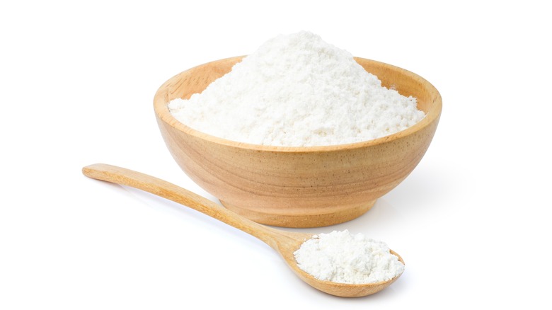 white cornstarch in a wooden bowl with a spoon