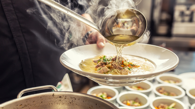 ladling hot chicken noodle soup