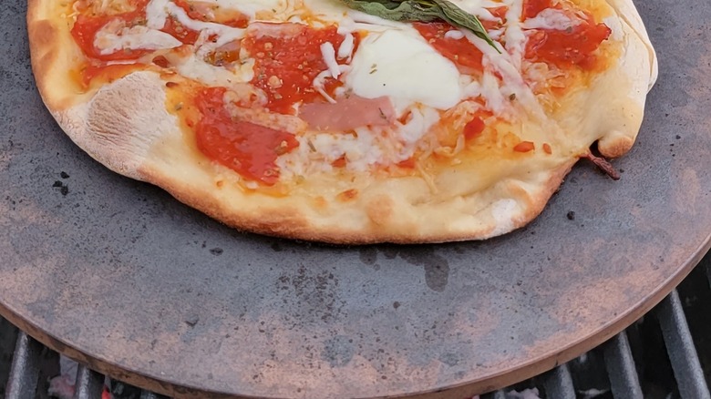 Pizza grilling on ceramic stone