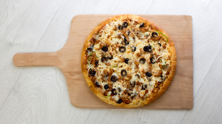 Chicken pizza on wooden peel