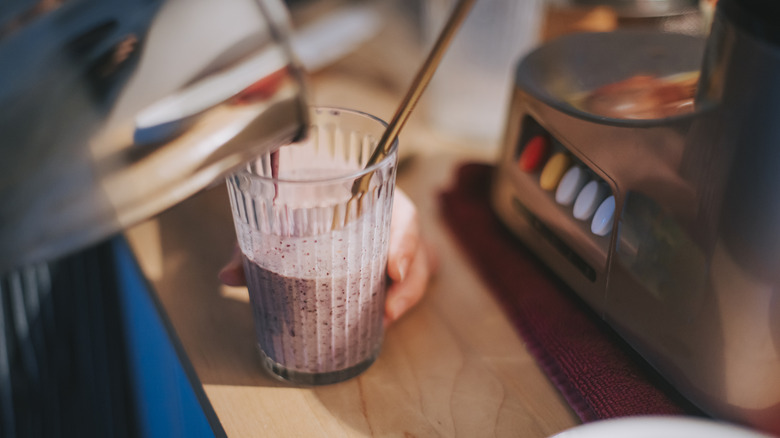 Person with smoothie in cup