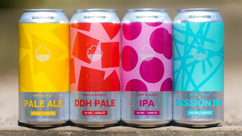 A selection of Cloudwater beer cans sitting atop a wall