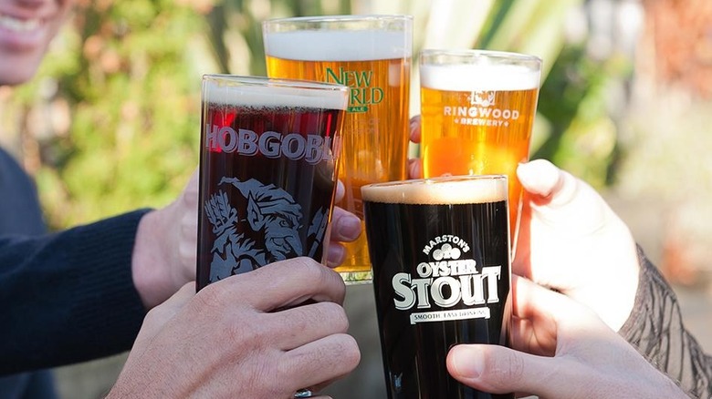 A selection of Marston's beer being clinked together by friends