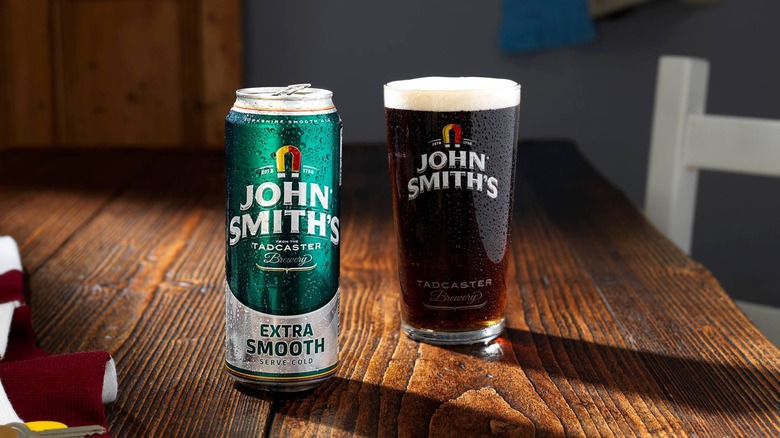 A can of John Smith's Extra Smooth and a full pint glass on a table
