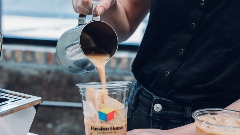 barista pouring iced coffee