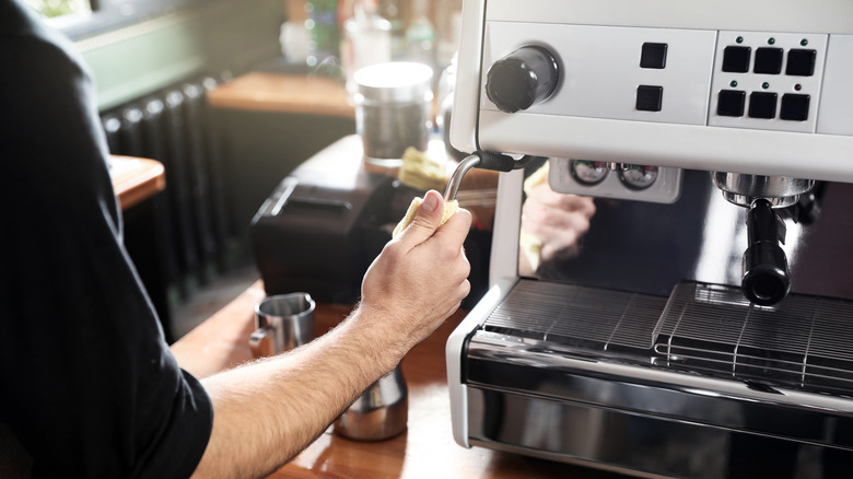 Barista cleaning steam wand