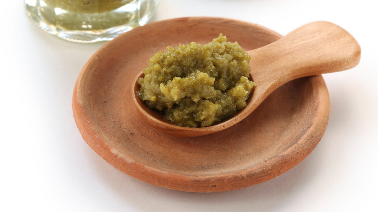 Spoon of yuzu kosho paste on wooden saucer