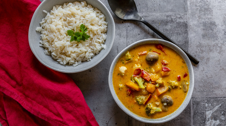 Bowl of vegetable curry with side of white rice