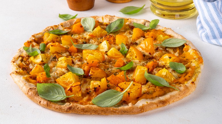 Vegetarian pizza with pumpkin sauce and basil