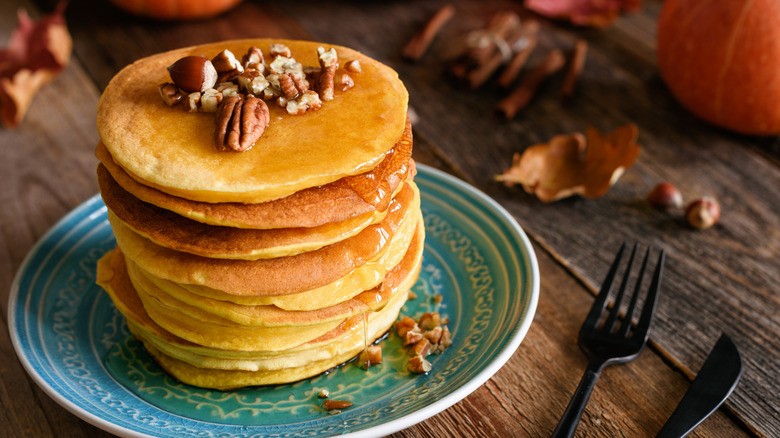 Stack of pumpkin pancakes with nuts on top