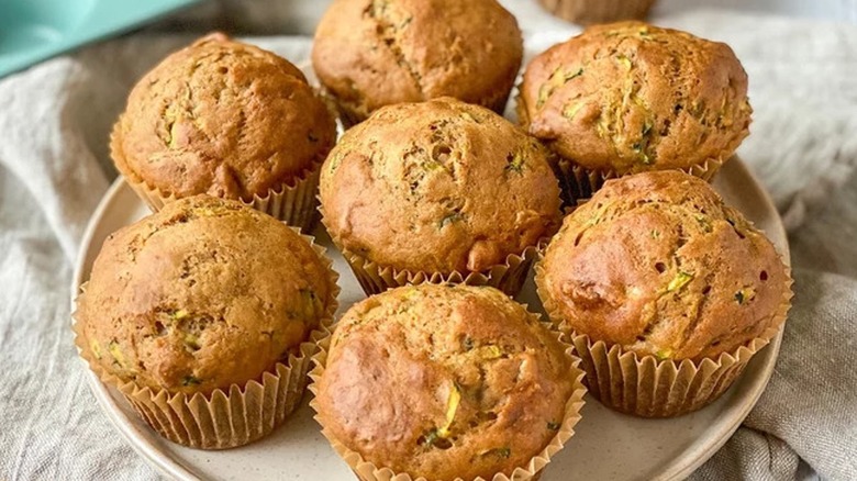 Seven zucchini and banana muffins on a plate