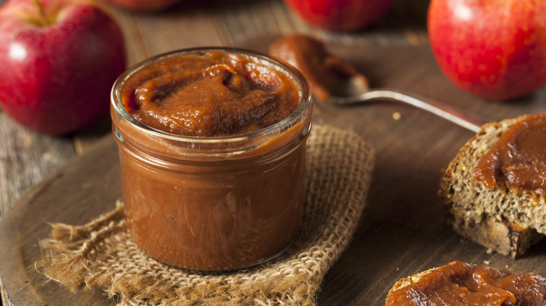 A jar of apple butter sits on a table.