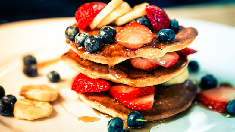 Pancakes are topped with fresh fruit.