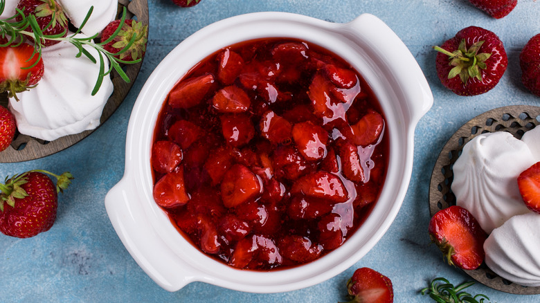 Strawberry compote fills a white dish.