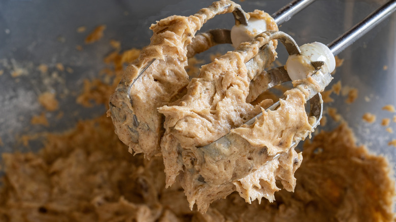 Honey cinnamon butter is coating the beaters of a mixer.