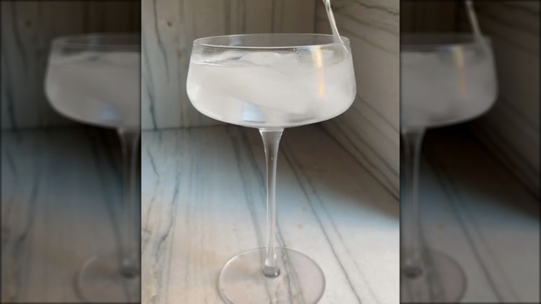 Chilling cocktail glass with ice water