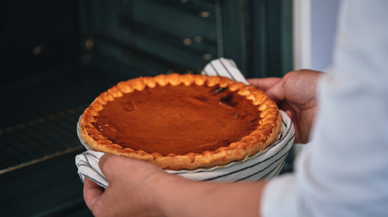 Person baking pie in oven