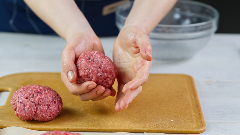 Hands shaping burger patty