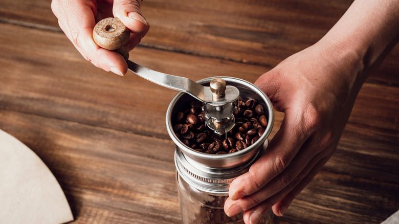 Manually grinding coffee beans