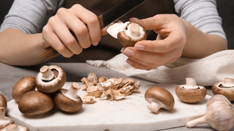 Peeling cremini mushrooms with knife