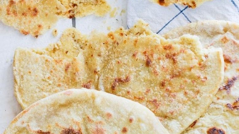 Torn Peshwari naan on white