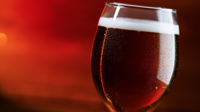 Glass of amber ale on a red background