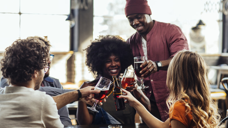 Group of friends toasting with beer at a pub