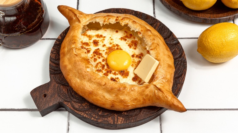 Khachapuri with cheese, egg, butter and lemon