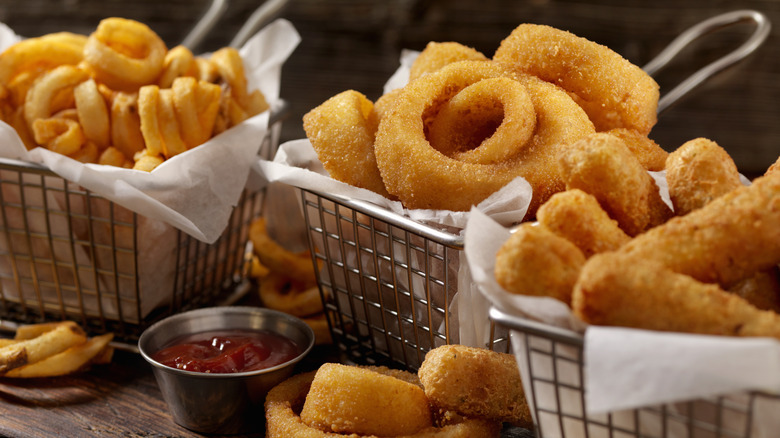 Deep fryer baskets with fresh golden onion rings