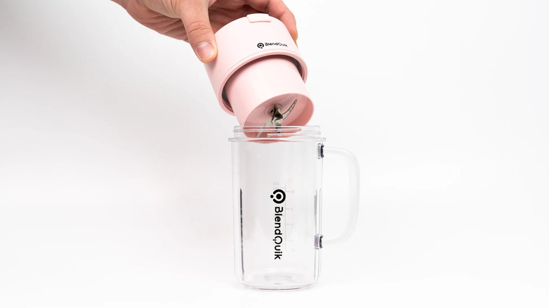 A hand holding a BlendQuik portable blender on a white background