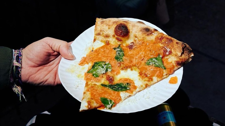 Pizza slice on a paper plate