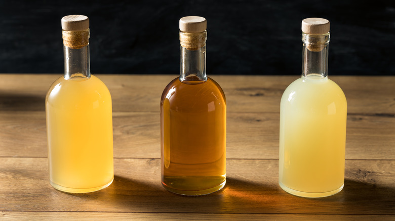 Three batched cocktails on a wooden table