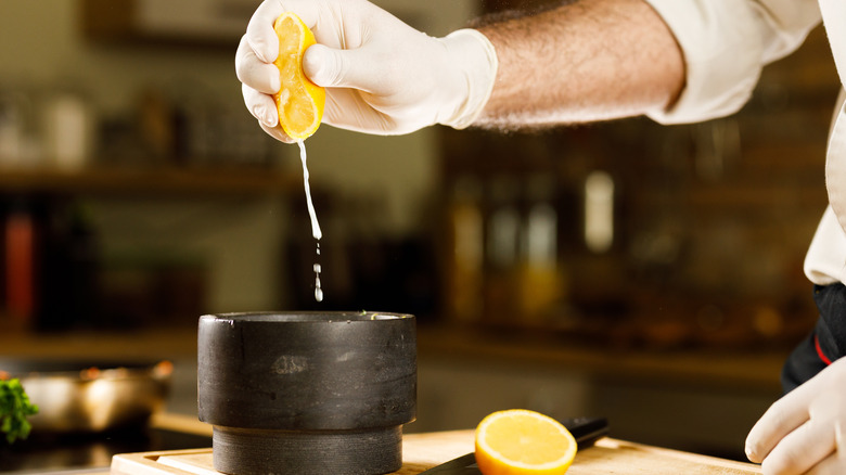 person squeezing lemon into bowl