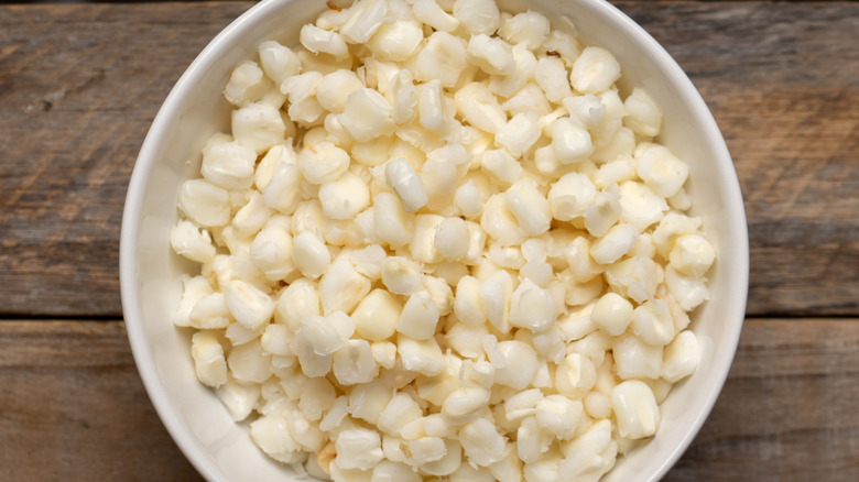 white bowl of hominy wooden table