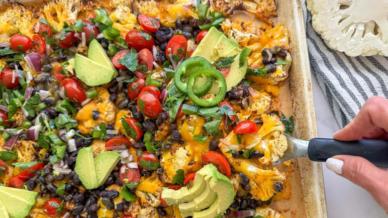 Cheesy Low(er) Carb Cauliflower Nachos with hand scooping serving