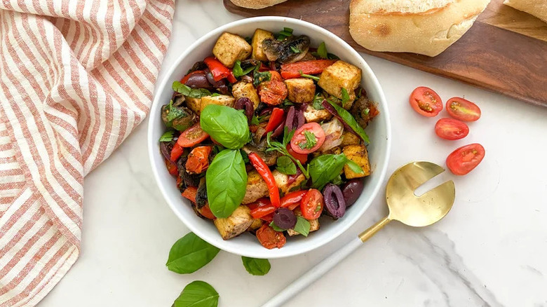 Mediterranean Sheet Pan Tofu in bowl with gold spoon