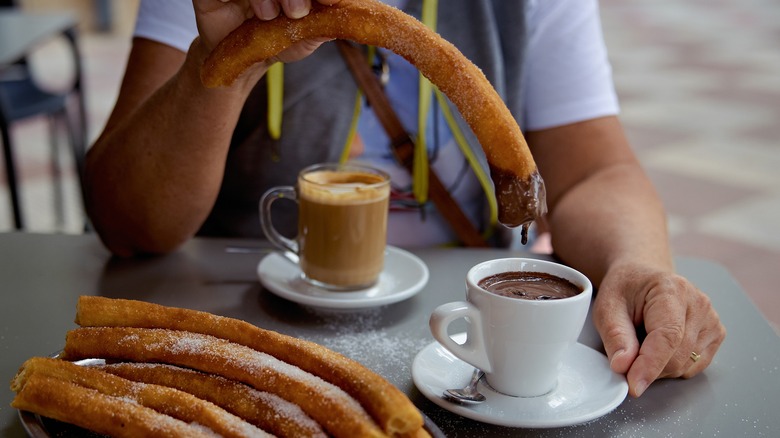 churros with chocolate and coffee on table