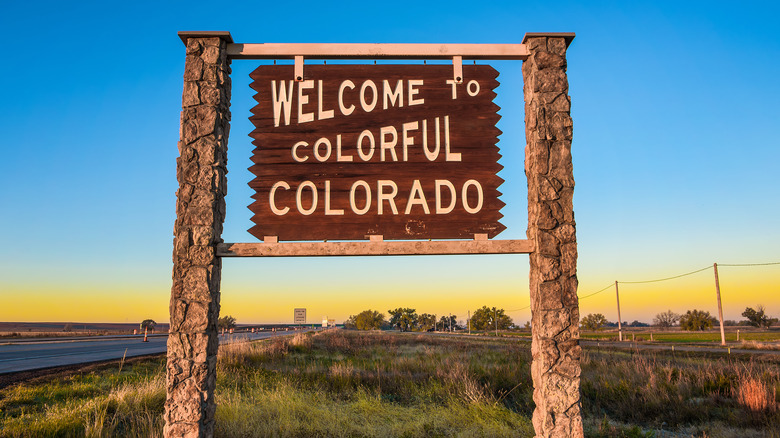 Wooden welcome sign against sunset