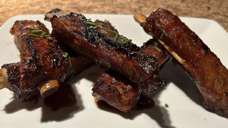 Glazed ribs arranged on white plate