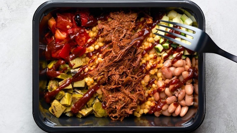 Fork digging into meat bowl