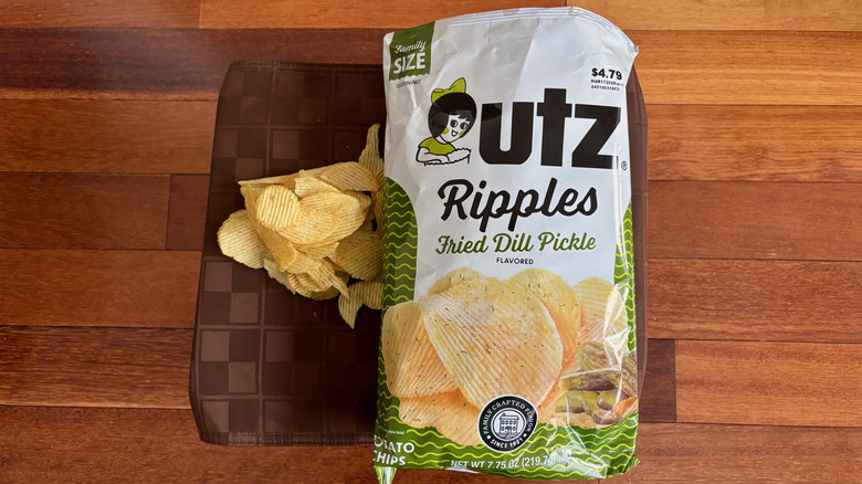 Small pile of Utz Fried Dill Pickle Ripples on a placemat next to open bag