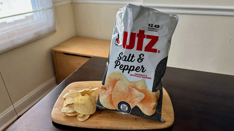 Utz Salt & Pepper chips on small cutting board next to open bag