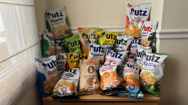 Bench piled with 22 bags of different flavored Utz potato chips