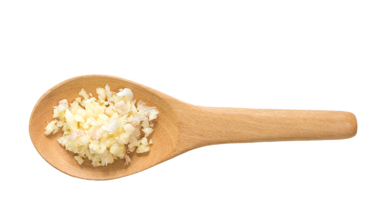 Minced garlic in wooden spoon