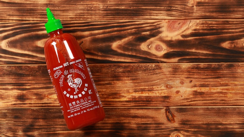 Bottled Sriracha on wood table