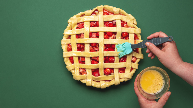 hand washing pie crust with eggs