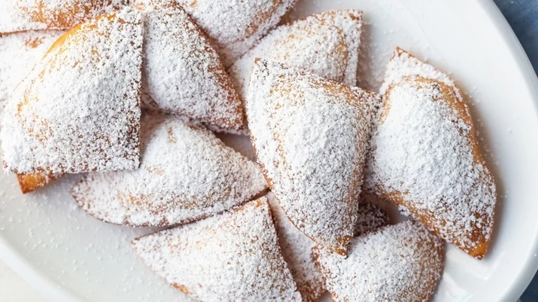 Sopapillas on a plate dusted with sugar