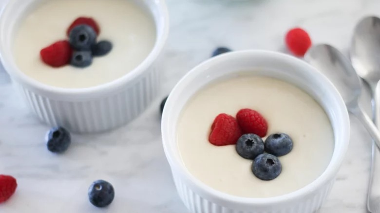 Two cups of vanilla pudding with berries