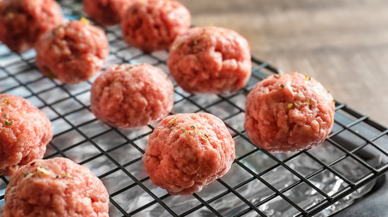 Raw meatballs on baking rack