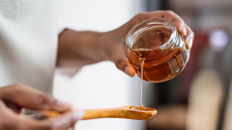 Pouring honey into spoon